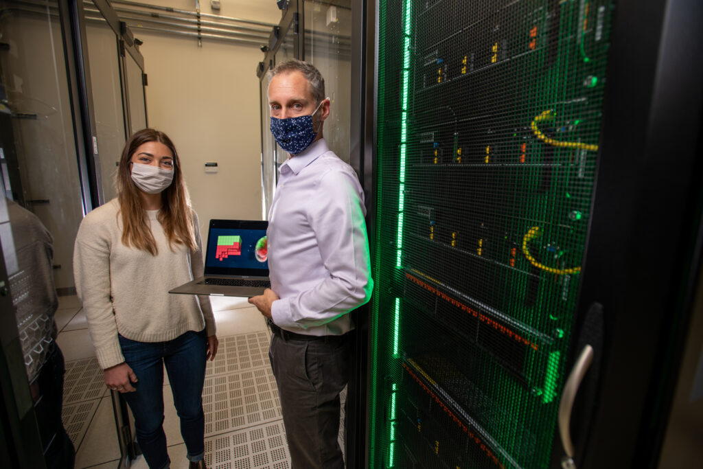  Lab member Caitlin Grasso and Prof. Bongard discuss xenobots next to the DeepGreen supercomputing facility where they were designed.